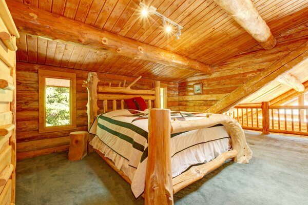 Großes Bett in einem Holzhaus