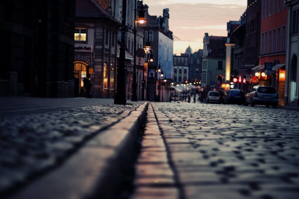 Lumières de nuit se reflétant sur les pavés de pierre de la rue de la ville