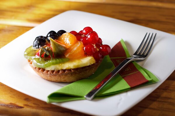 Törtchen mit Fruchtstücken und Beeren auf einem Teller