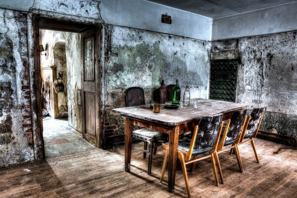 Salle à manger abandonnée avec grande table et chaises