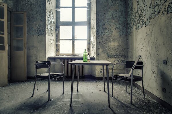 Bouteille sur la table dans une pièce en lambeaux