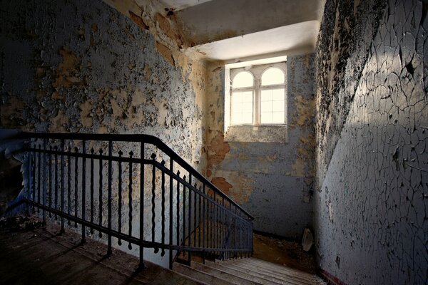 Escalier sur fond de peinture écaillée sur les murs