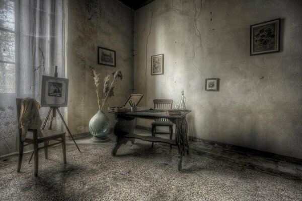 A very sad room with a chair and a table in it