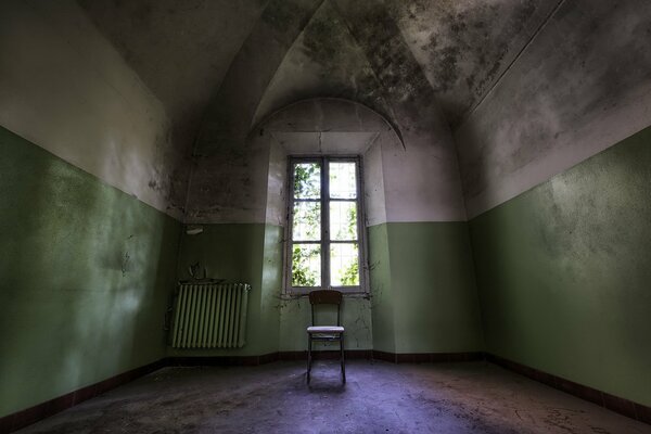 Chambre sombre avec une fenêtre et une chaise