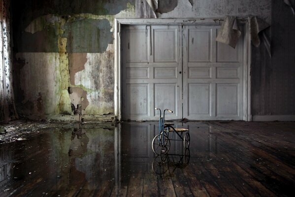 An empty room without wallpaper, there is a bicycle in the middle, the doors are completely closed