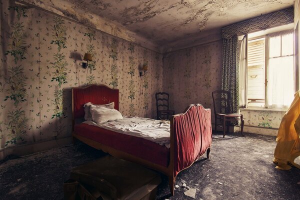 An abandoned old room with an unmade bed