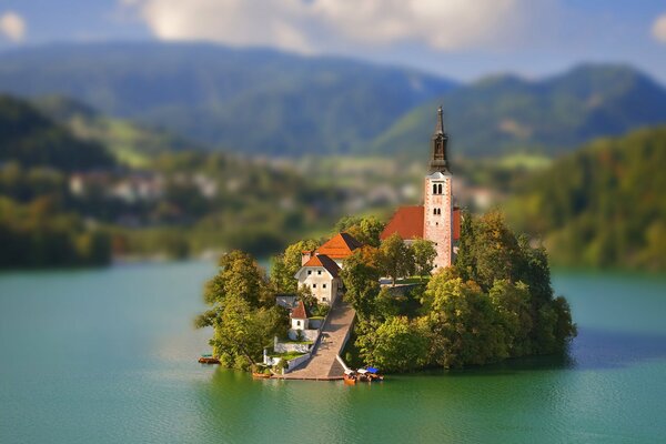 A house with a tower on an island in a lake