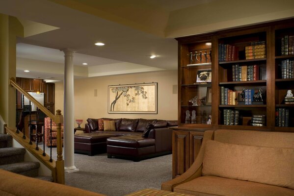 The interior of the living room with a leather sofa, library and right hand