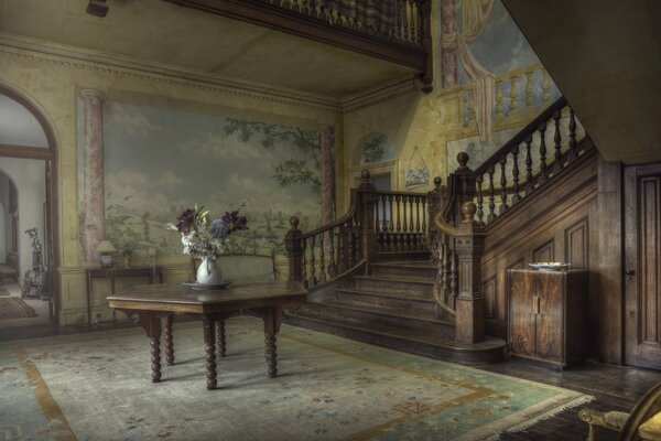 A room in a mansion with flowers on the table