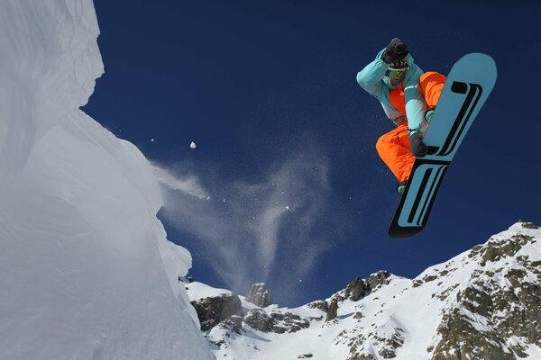 Atleta nel salto sullo snowboard in inverno in montagna