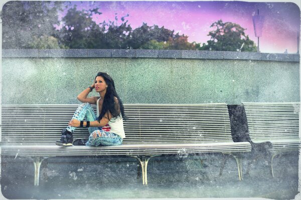 Beautiful girl sitting on a bench at dawn