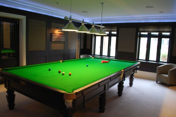 Billiard table in the room with a hanging lamp