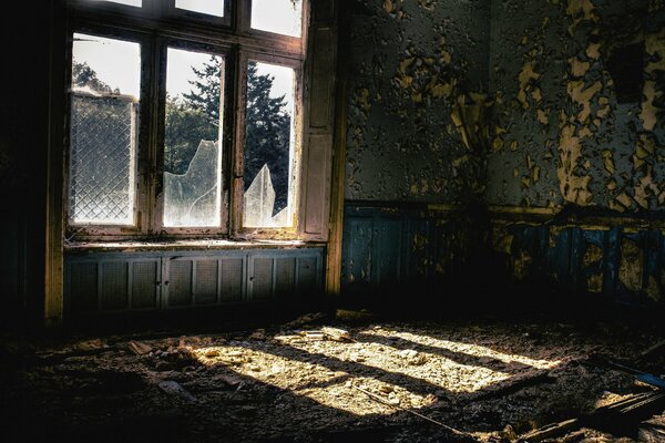 Casa abandonada con cristales rotos en la ventana vista desde el interior