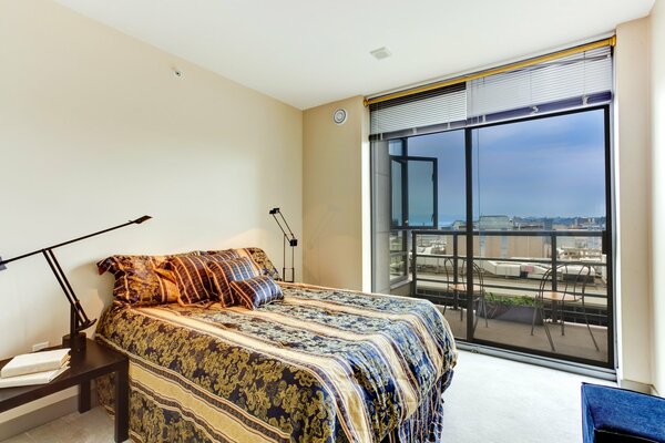 Interior of a bedroom with a bed and a balcony