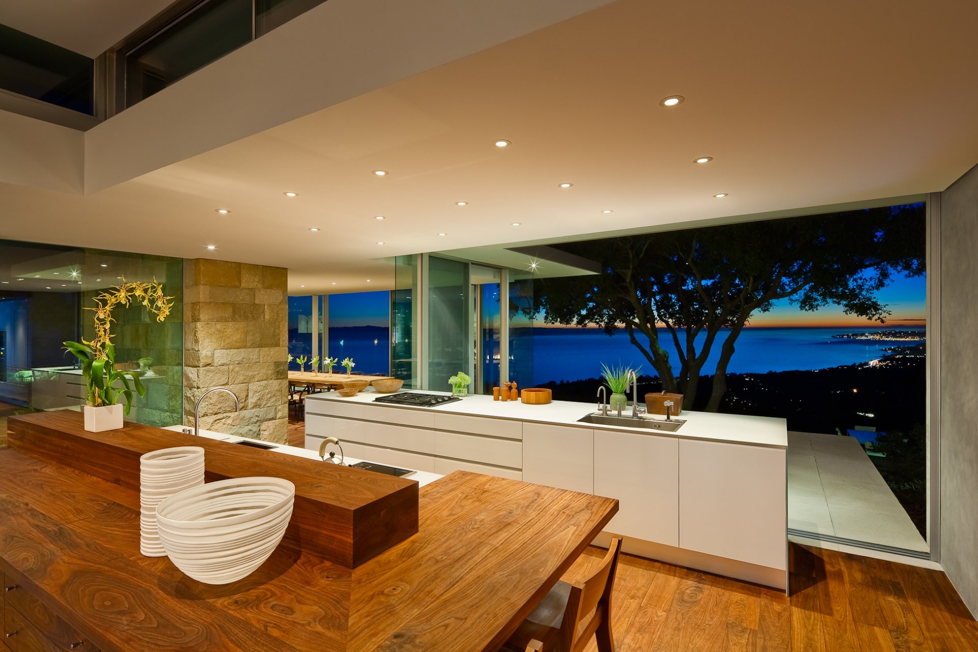 interior cocina estufa armarios mesa sillas jarrones flores ventana árbol vista casa luces costa