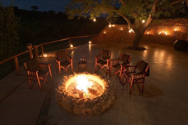 Stimmungsvoller Abend auf der Terrasse mit Wein rund ums Feuer
