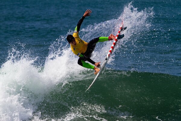 Surf. Homme en sautant sur une vague avec une planche