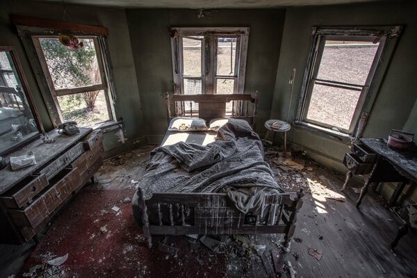 A large room with windows in an abandoned house