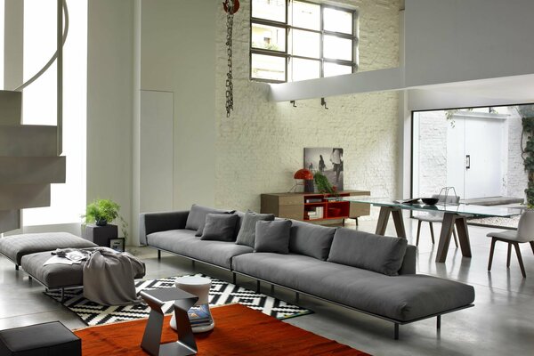 Designer-Wohnung mit grauem Sofa und rotem Teppich