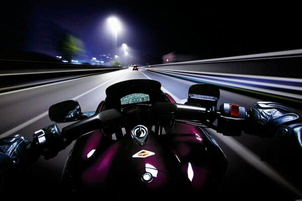 Un motocycliste fait le tour de la ville de nuit