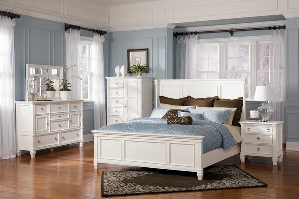 Camera luminosa con letto e mobili bianchi