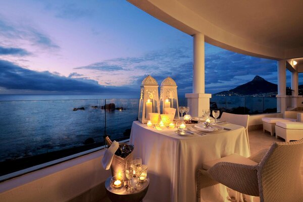 Cena elegante junto al océano en la iluminación de velas