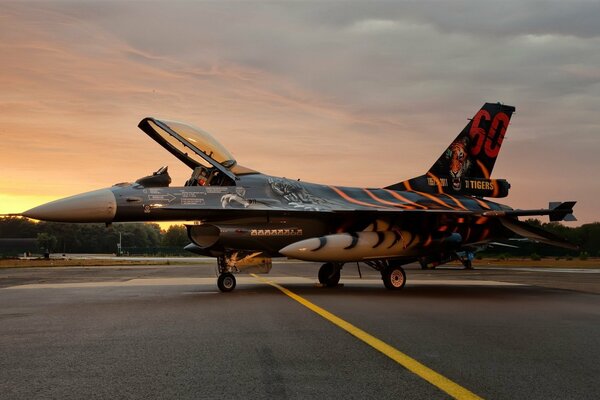 A fighter jet on the background of sunset is ready to take off