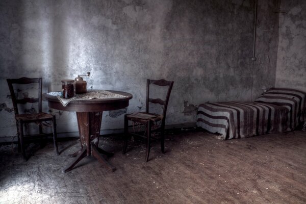 Muebles viejos en mal estado en una habitación gris