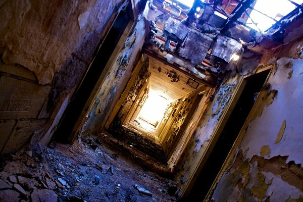 La ruine, la saleté et la lumière au bout du tunnel. Le toit de la salle est tombé . Peeling chauffage autonome dans la porte