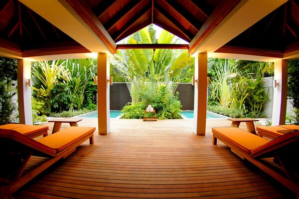 Das Innere des Pools:Liegestühle und Tische vor dem Hintergrund des tropischen Grüns