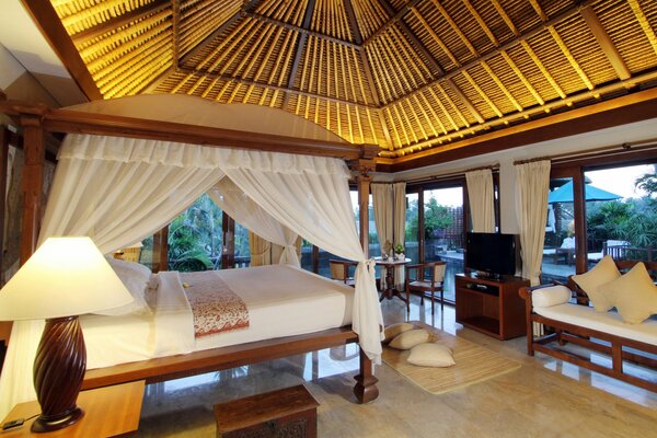 Guest bedroom under the canopy of the pavilion of a country villa, four-poster bed