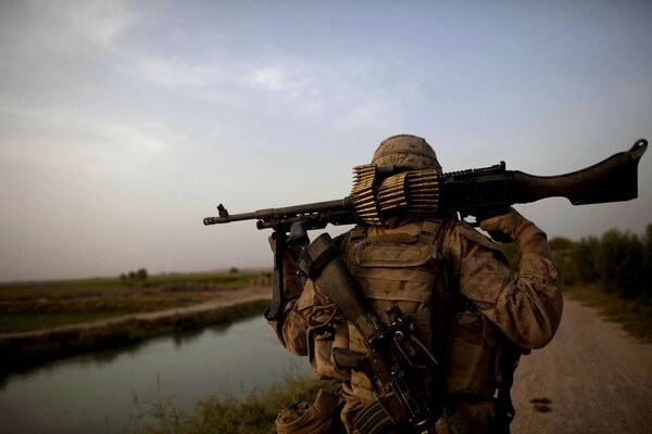 Soir. Soldat sur la route avec un fusil