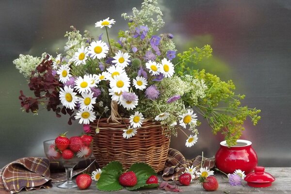 Composición de la imagen de flores de riego y bayas en la mesa