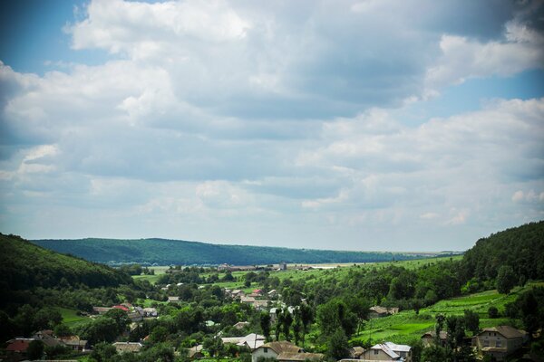 Ruhiger blauer Himmel mit Wald und Dorf