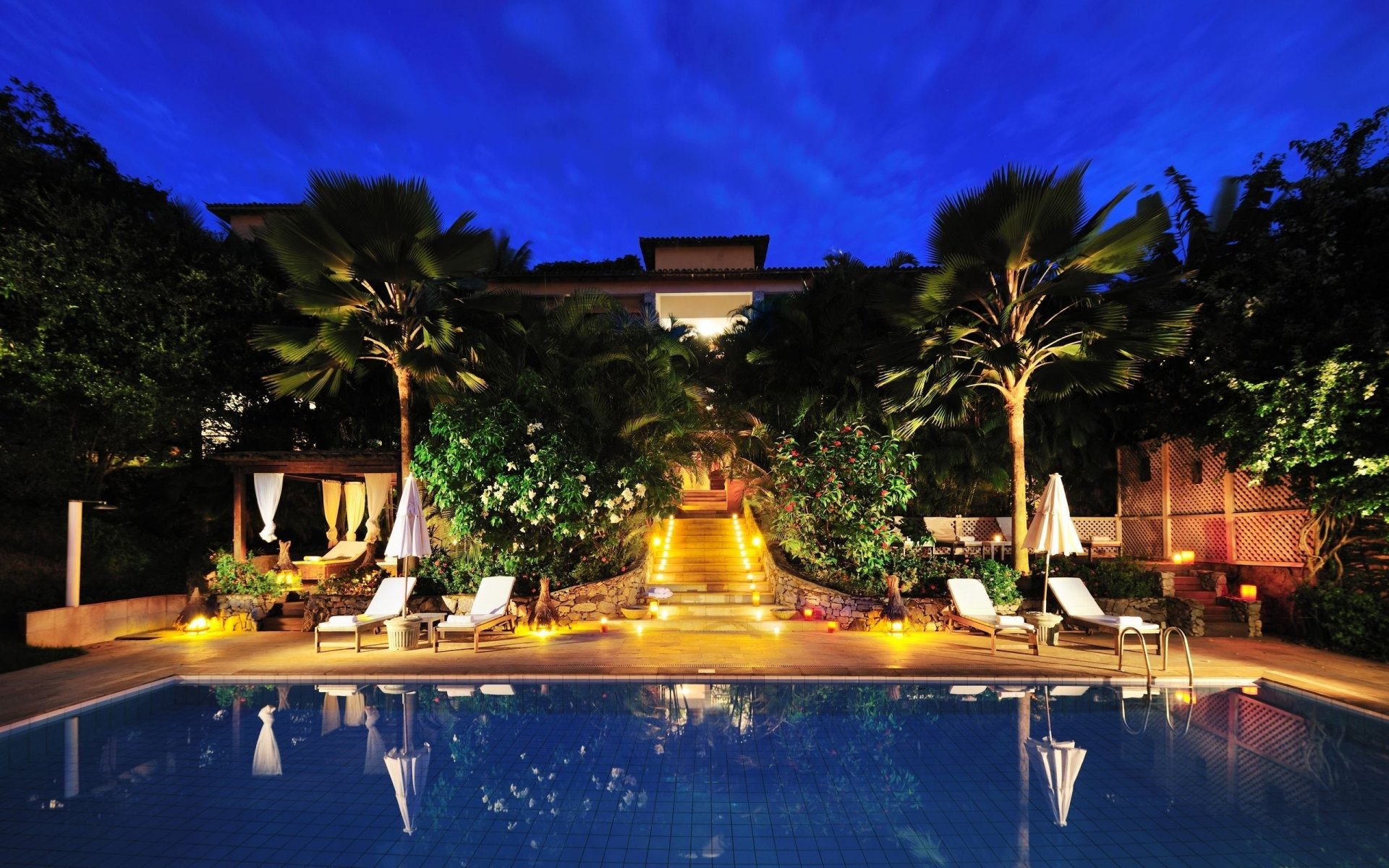 soirée hôtel palmiers arbres plantes piscine meubles chaises longues