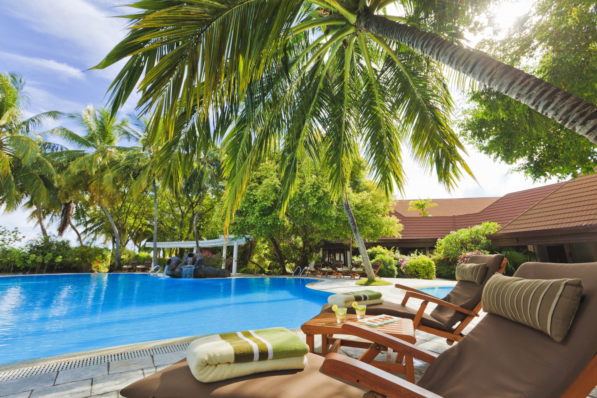 piscina hotel maldivas exterior tumbonas mesa palmeras árboles