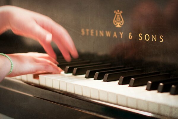 Исполнение музыки на рояле. Руки пианистки вблизи