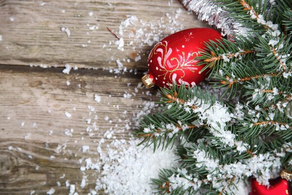 Juguetes de Navidad en una rama en la nieve