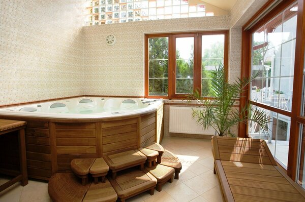 A bright room with a Jacuzzi and a beautiful view from the window