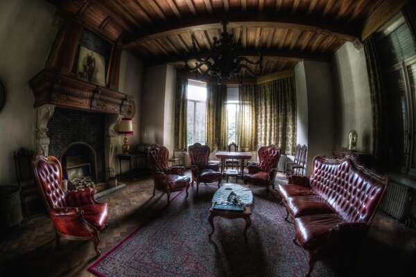 The interior of the mansion has a fireplace in the large room and a sofa and chairs in the circle