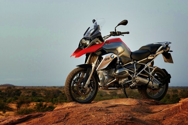 Moto bmw rouge et noir sur fond de savane