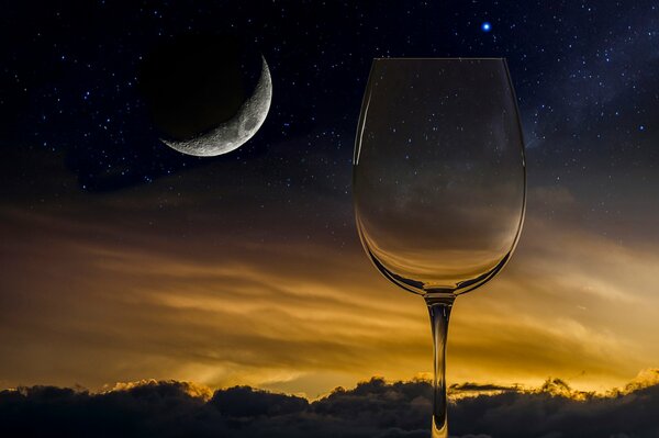 Una Copa de vino contra el cielo estrellado y el mes