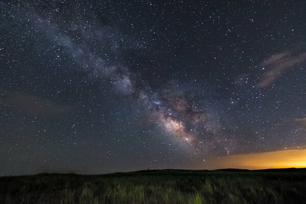 Campo e stelle notturne della Via Lattea