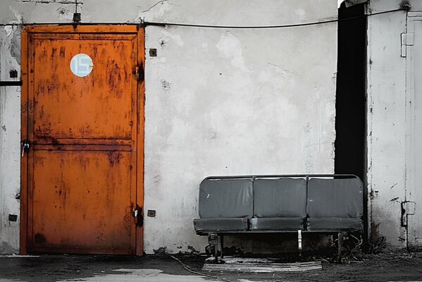 An old upholstered bench by the brown door