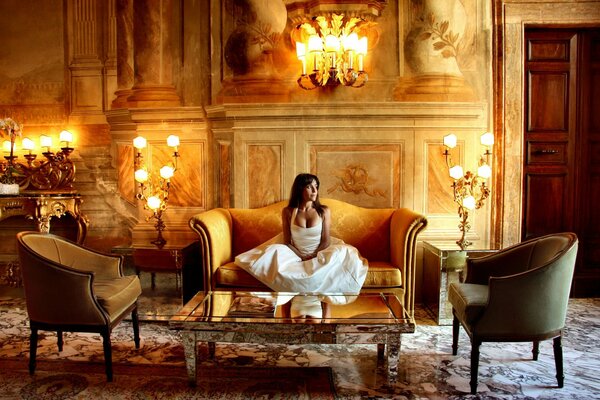 Morena chica en vestido blanco en el castillo