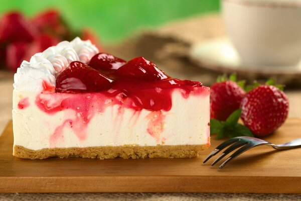 A piece of cheesecake with strawberries and cream