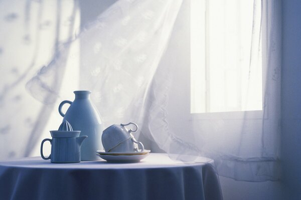 Dawn in a room with a white curtain and dishes