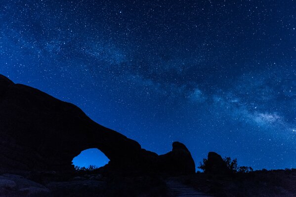 Montañas en el fondo del cielo nocturno, la vía láctea visible