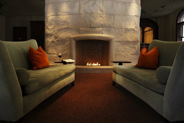 Gray sofas by the lit fireplace