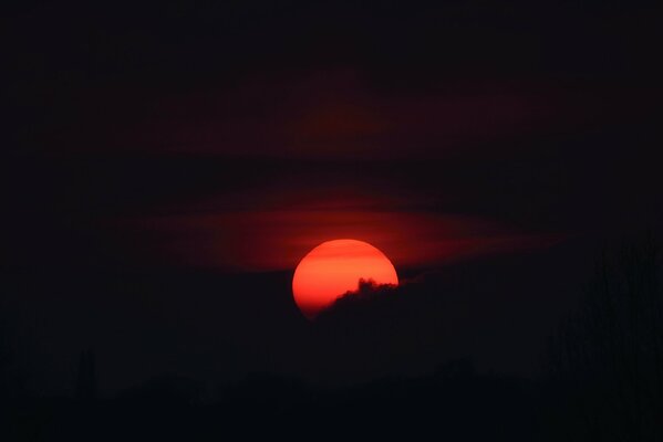 Sonnenuntergang - Der Mond ist wegen der Wolken im Blut
